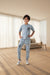 Child wearing a gray outfit with 'Rama Kids Wear' branding, standing against a white curtain background.